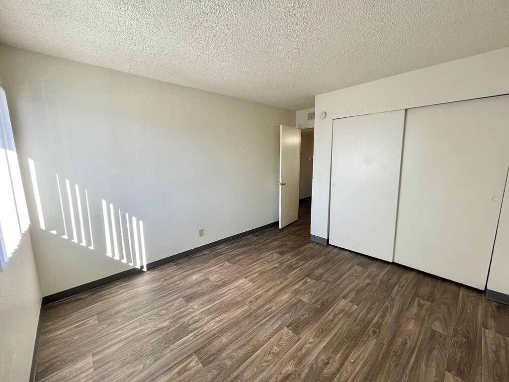 A room with wooden flooring and white walls.